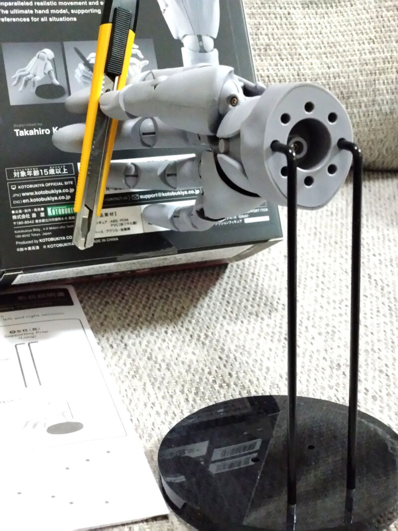 長い支柱に固定したコトブキヤハンドモデル(右手/グレー)に定番カッターナイフを持たせてみた。手首の裏側に穴が開いている。ここに支柱を差し込む。